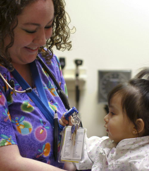 Nurse holding toddler.