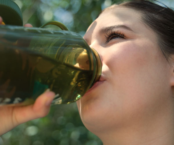 Woman drinking water from a water bottle.