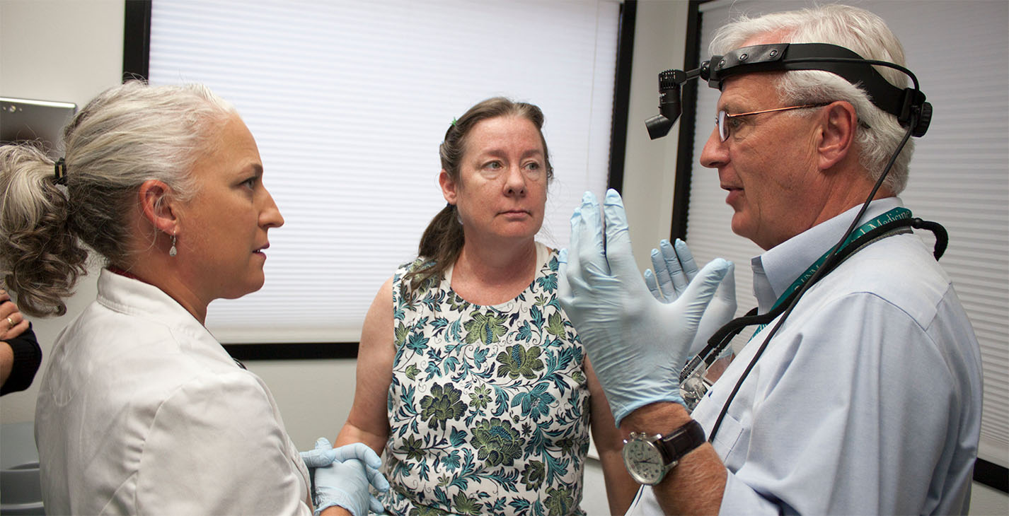 two doctors talk to a patient about her treatment options