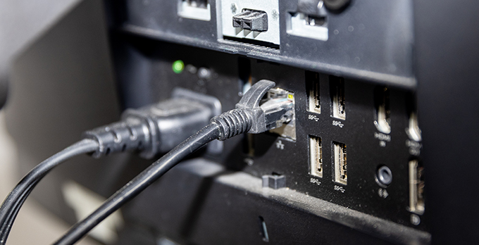 The back of a computer panel with an ethernet cable sticking out