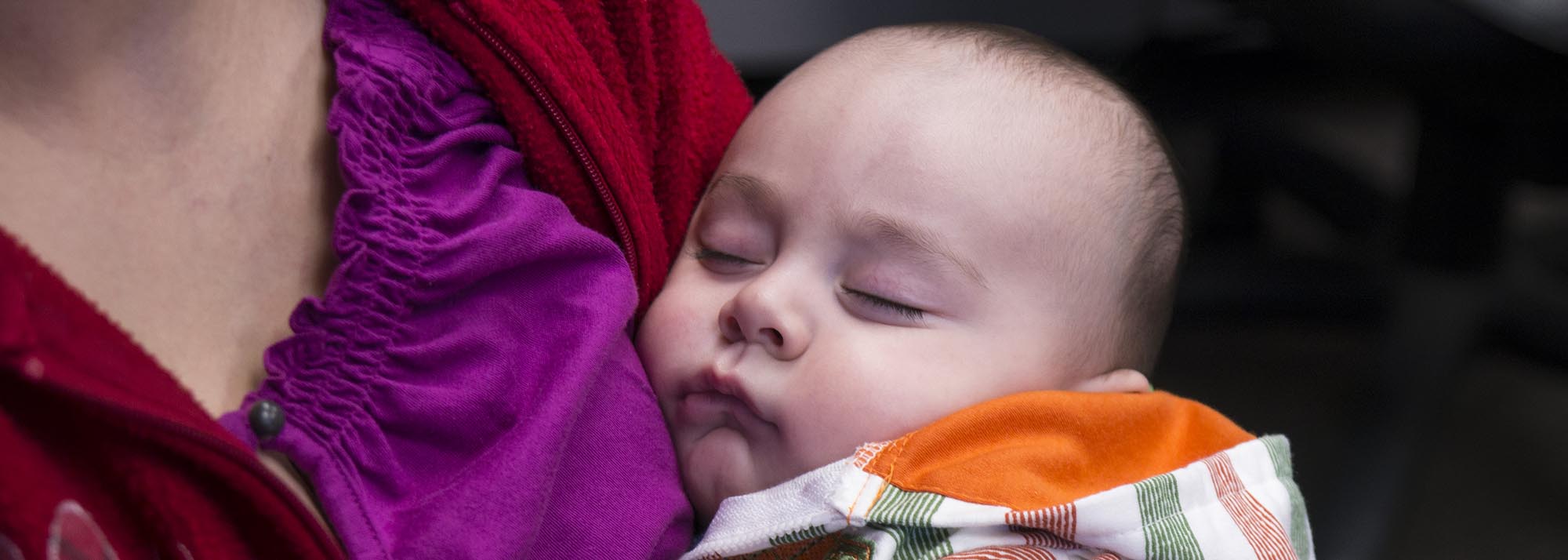 A newborn being held by their parent