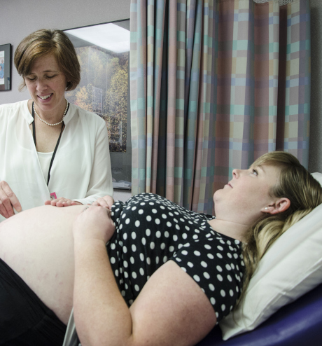 Geburtshelfer untersucht schwangere Frau.
