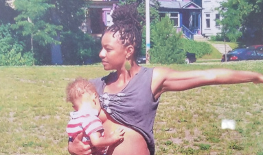 Donyelle breastfeeding her baby while doing yoga.