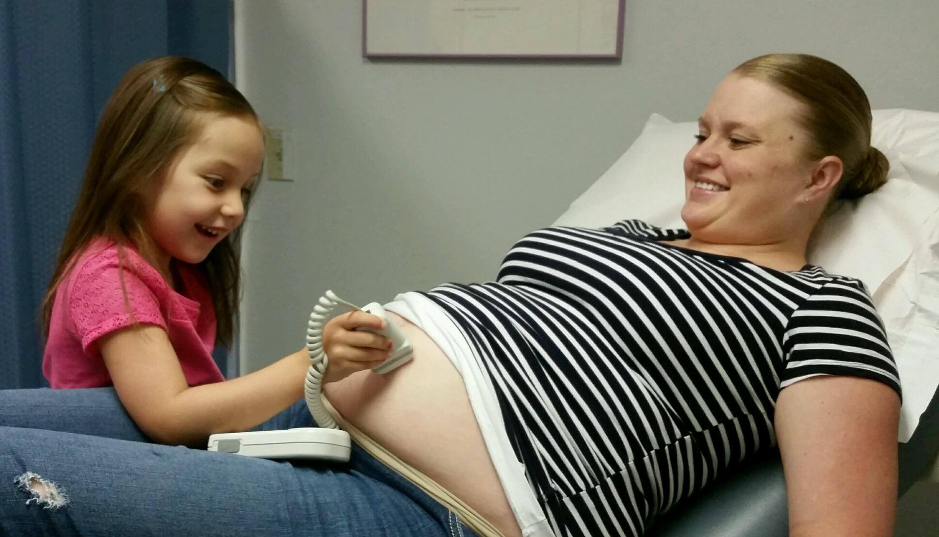 Ein Kind verwendet einen Ultraschall bei seiner werdenden Mutter