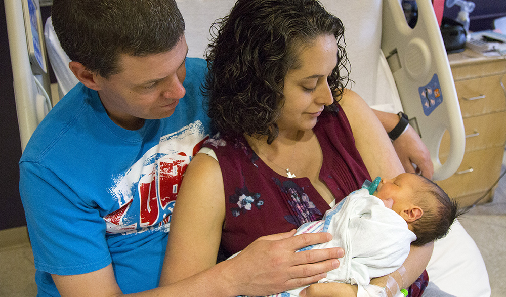 Una madre y un padre sosteniendo a su nuevo bebé.