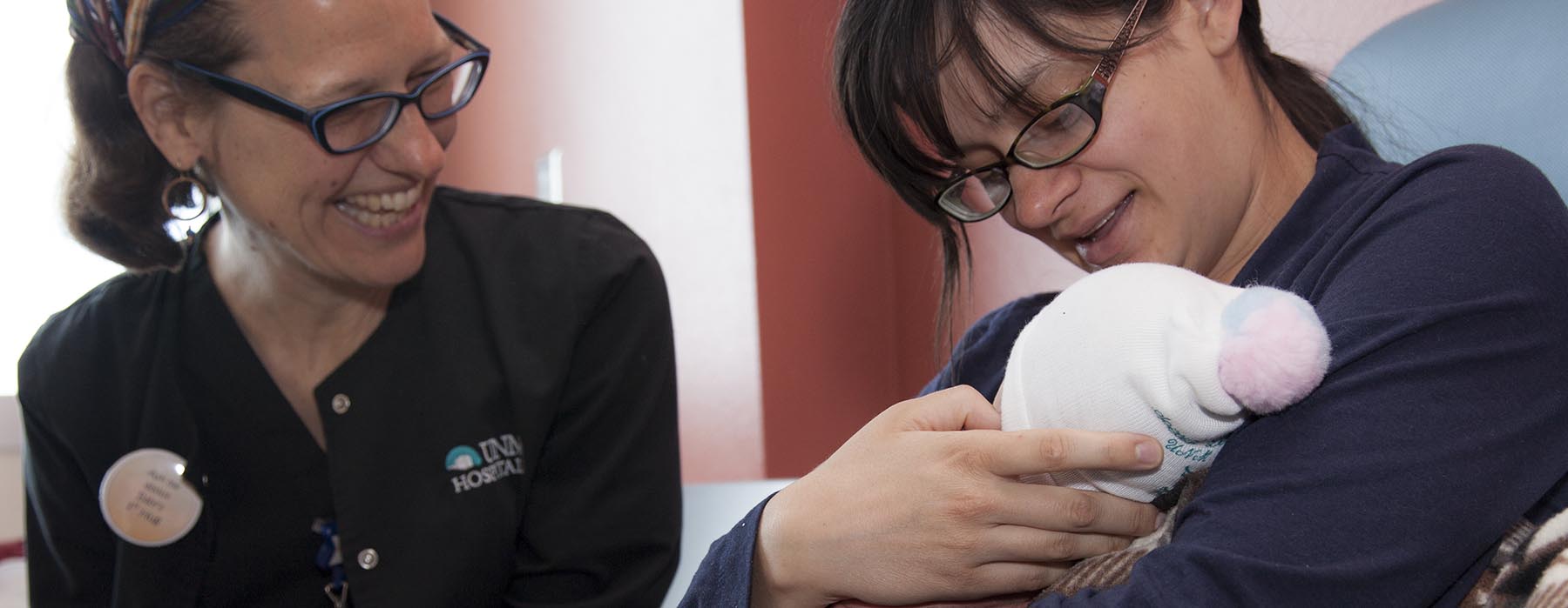 Una proveedora de la UNM ayudando a una madre a amamantar