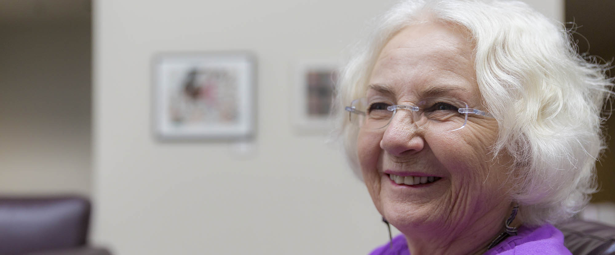 An older person smiling in a waiting room