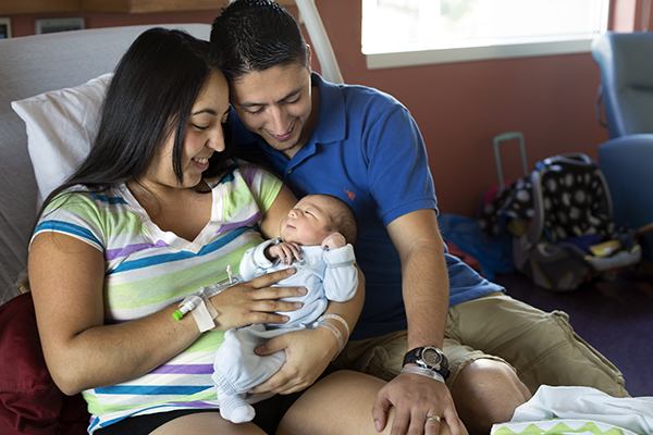 Una madre y un padre sosteniendo a su recién nacido.