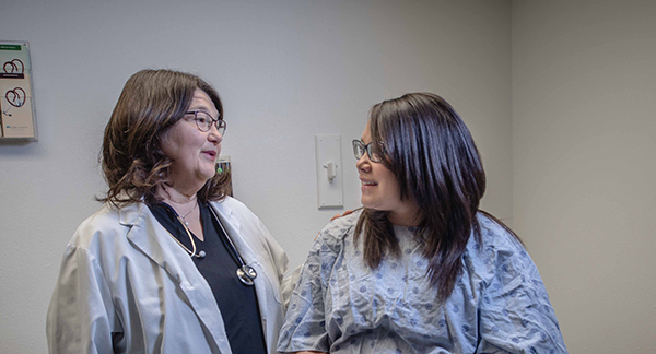 A woman talking to a physician