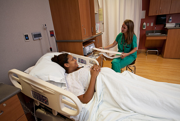 Una mujer embarazada hablando con la enfermera.