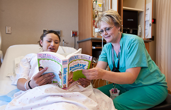 Một người mẹ đang mong đợi đọc tên con với một y tá