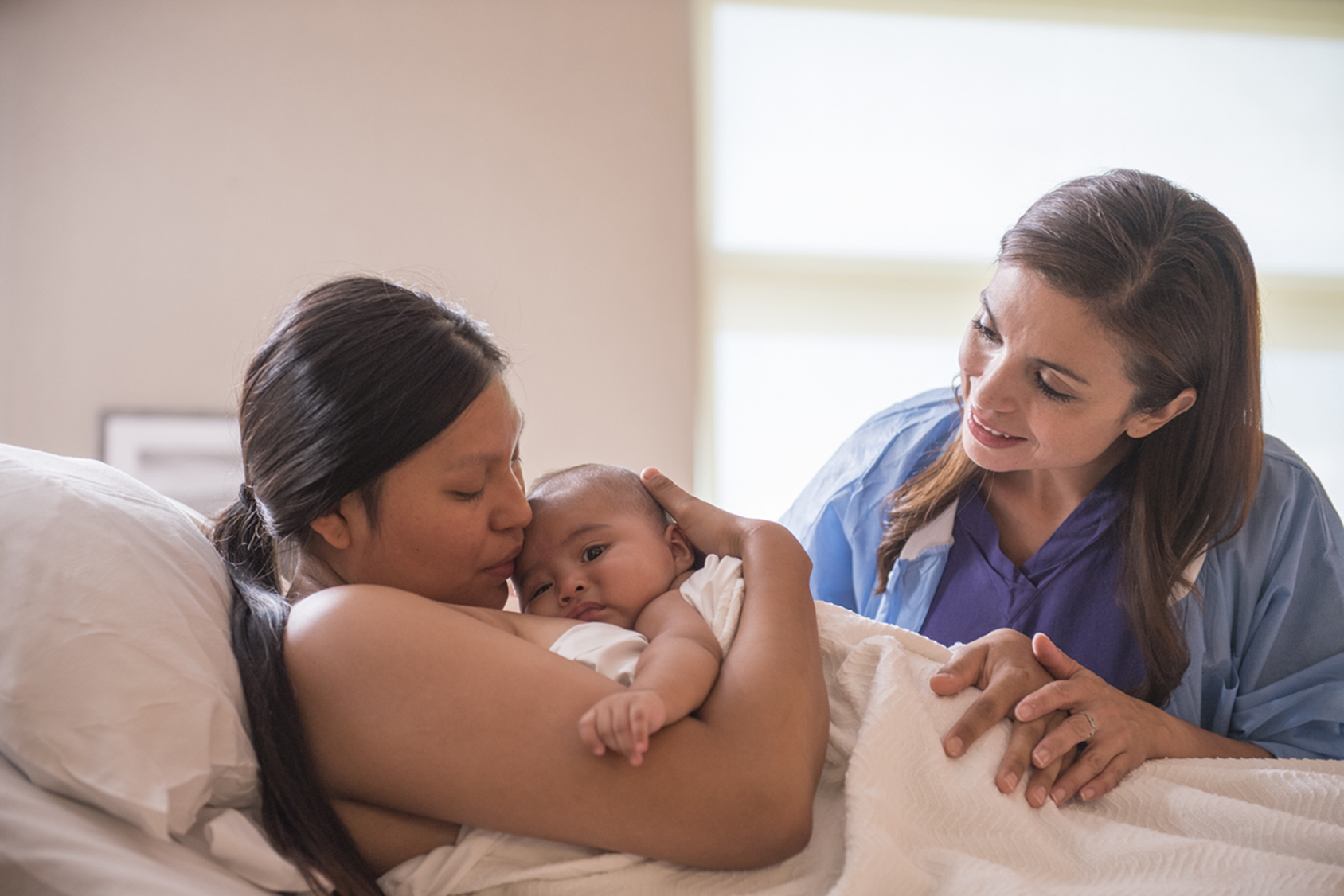 Una enfermera y una madre con su recién nacido.