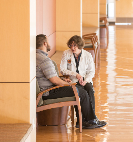 Doctor speaking with patient in hallway.