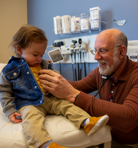 Pediatrician listening to toddler's heart.